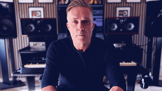 Candid studio photograph of ambient and trance artist Nicholas Gunn creating electronic music, surrounded by synthesizers used to produce his signature melodic house and chillout tracks.